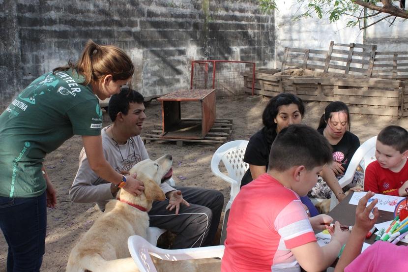 Une volontaire de Projects Abroad aide un jeune homme handicapé, lors d’une session de thérapie canine. Une volontaire de Projects Abroad aide un jeune homme handicapé, lors d’une session de thérapie canine.