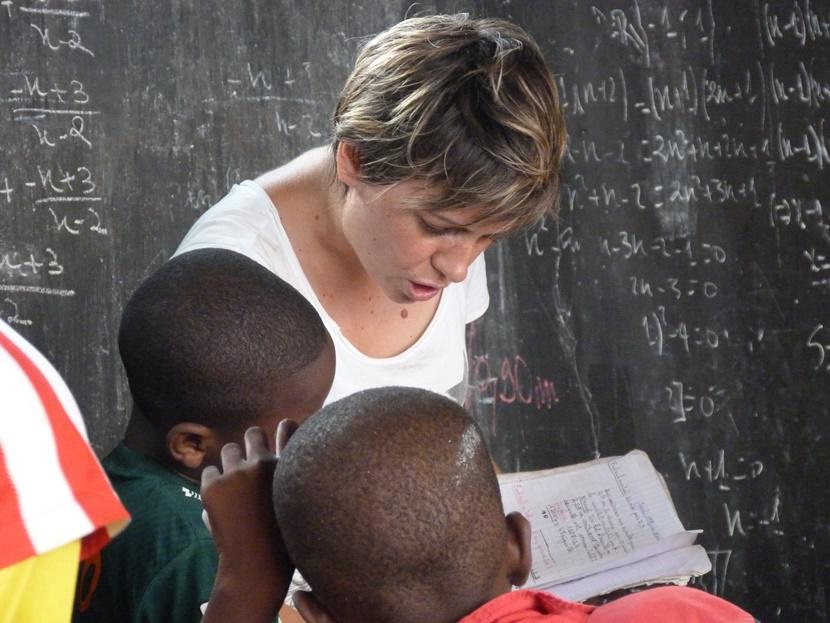 Un volontaire participant à une mission humanitaire fait de la lecture aux enfants dans un orphelinat au Togo.