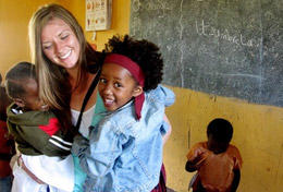 Tanzania A volunteer hugs children on her Care & Community High School Special in Tanzania.