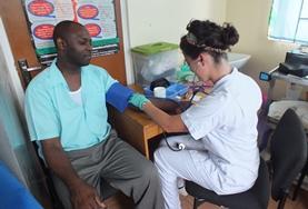 Belize Public Health volunteers on a High School Special project measure the blood sugar levels of a local man during an outreach in Belize.
