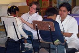 Medicine & Health Care High School Special medical volunteers in Bolivia check children's heartbeats.