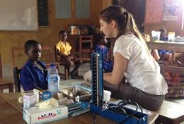 Ghana A Medicine High School Special volunteer checks a young boy's vital signs in Ghana.
