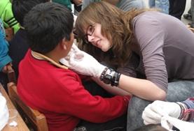 Peru A volunteer on the Medicine High School Special in Peru does an eye test with a local boy.