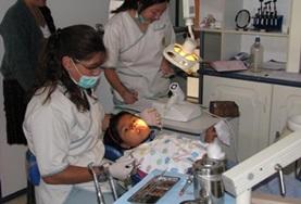 Medicine & Health Care A dentist and intern on the Dentistry Internship in Bolivia prepare a young girl for her dental appointment in Bolivia.
