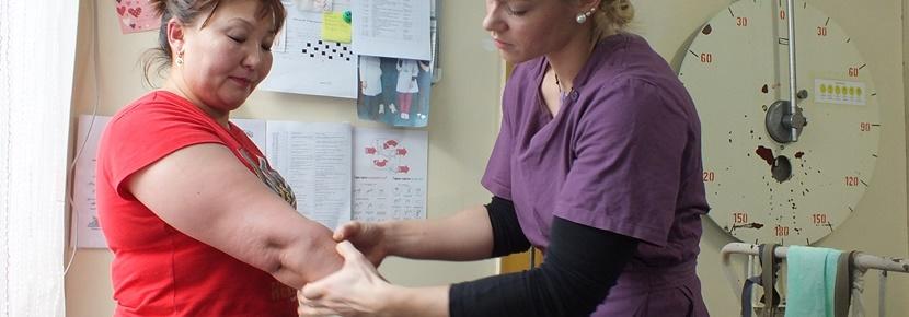An intern studying physiotherapy examines a patient under the supervision of a local therapist abroad. An intern studying physiotherapy examines a patient under the supervision of a local therapist abroad.