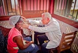Ghana A volunteer doctor examines a local woman in Ghana as part of his project for professionals.