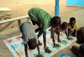Ghana An occupational therapist volunteer assists a child in Ghana with a classroom activity.