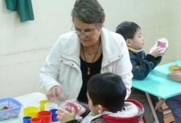 Vietnam Based in Vietnam, a professional occupational therapy volunteer assists a young child during a therapy session.