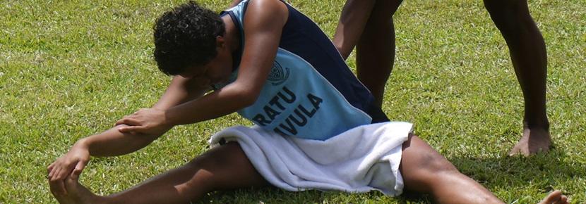 A volunteer helps his student stretch while on his Sports Project abroad A volunteer helps his student stretch while on his Sports Project abroad